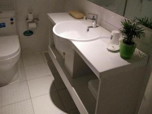 a white bathroom with a sink and a toilet at GreenTree Alliance Nantong Chongchuan Fangtian Market Branch in Nantong