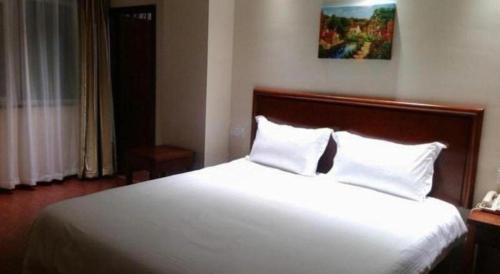 a bedroom with a large white bed with two pillows at GreenTree Inn Yancheng Vehicle Administrative office Test Center Express Hotel in Yancheng