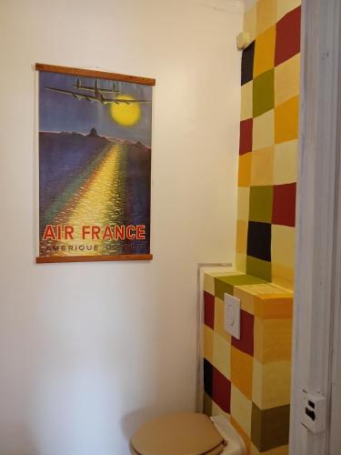 a bathroom with a poster of an air france at Le Mas Palegry Chambres d'hôtes Perpignan in Perpignan