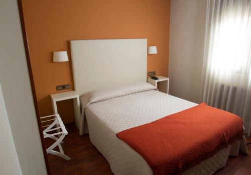 a small bedroom with a bed and a window at Hotel Ovetense in Oviedo