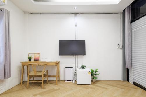 a living room with a table and a tv on the wall at Wabisabi Bangkok 3 MIN To Train Station in Bangkok