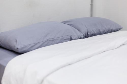 a bed with a blue pillow on top of it at Wabisabi Bangkok 3 MIN To Train Station in Bangkok