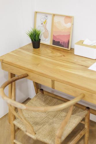 a wooden desk with a potted plant and a picture at Wabisabi Bangkok 3 MIN To Train Station in Bangkok