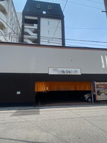 a building with a garage with a sign on it at ホテルシルクロード ＡｄｕｌｔＯｎｌｙ in Hiroshima