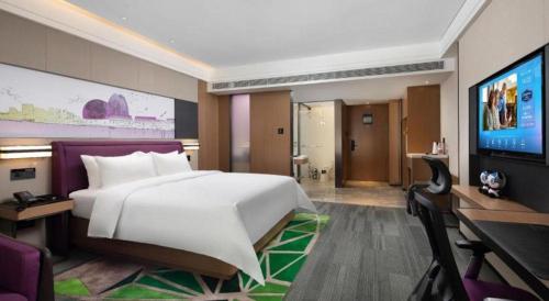 a hotel room with a large bed and a flat screen tv at Hampton by Hilton Zhuhai Doumen in Zhuhai