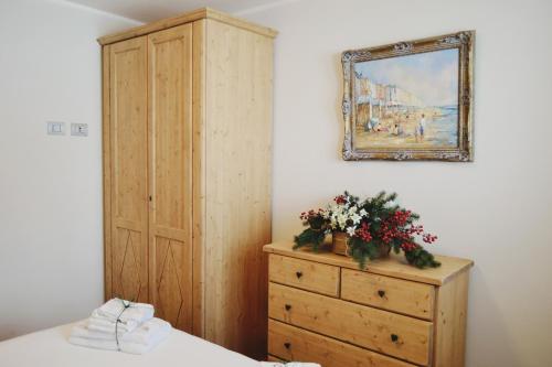 a bedroom with a dresser and a painting on the wall at Maison Carrel Elegant 8 in Breuil-Cervinia