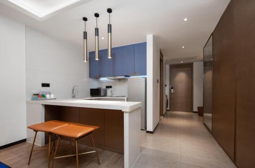 a kitchen with blue cabinets and a counter and stool at Changsha Feiji Hotel in Changsha