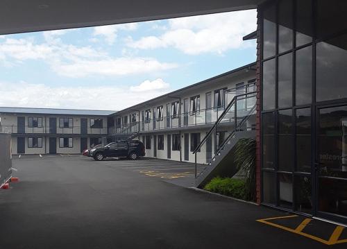 a car parked in a parking lot next to a building at Pokeno Motel in Pokeno