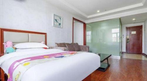 a bedroom with a large bed and a couch at GreenTree Inn Yinchuan Pedestrian Street East Liqun Street Express Hotel in Yinchuan