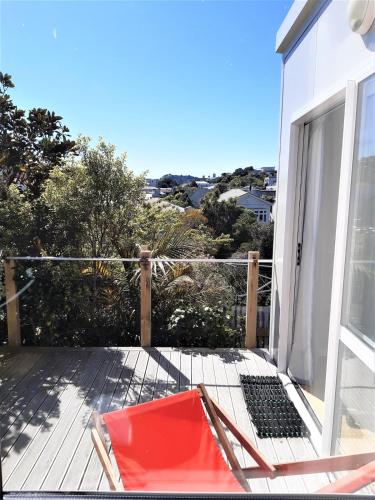 a deck with a chair and a sliding glass door at Peace and quiet in the Brooklyn hills in Wellington