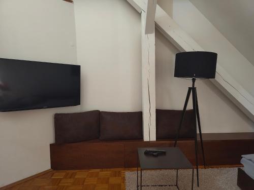 a living room with a couch and a flat screen tv at WHLIVING - Apartments & Studios in Konstanz in Konstanz