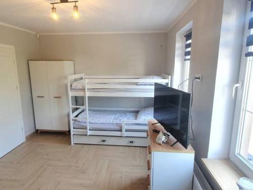 a room with a bed and a television in it at Pod Żaglami in Dąbki