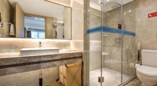 a bathroom with a toilet and a sink and a shower at Dalian Bohai Pearl Hotel in Dalian
