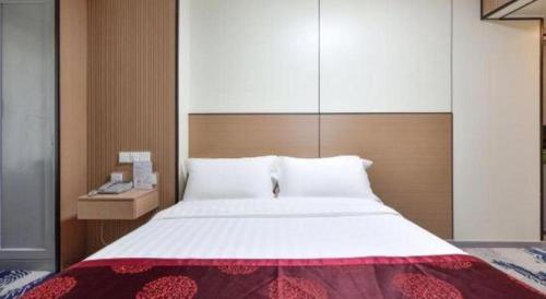 a bedroom with a large bed with a wooden headboard at Dalian Bohai Pearl Hotel in Dalian