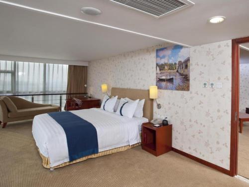 a hotel room with a bed and a balcony at Holiday Inn Express Tianjin Dongli By IHG in Tianjin