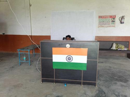 a person behind a podium with a flag on it at Hotel O Lord Krishna in Alīgarh