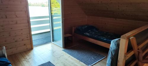 a small room with a bunk bed and a window at Przy jeziorze in Kaliska Kośierskie