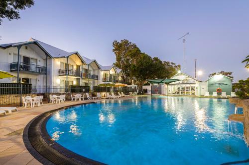a large swimming pool in front of some houses at Mandurah Quay Resort in Mandurah