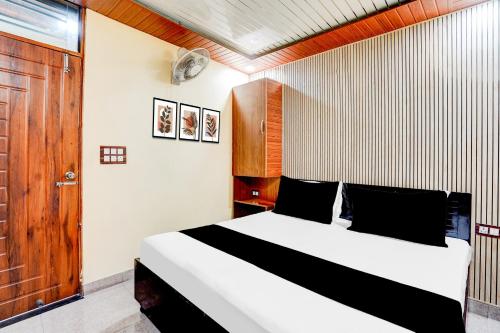 a bedroom with a bed and a wooden door at SPOT ON Hotel Doon Lotus | Iconic Rooftop Cafe | Party Hall in Clement Town
