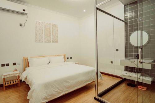 ZhangshanyingBeijing Meet the Mountain Boutique Guesthouse的带床和玻璃淋浴间的卧室