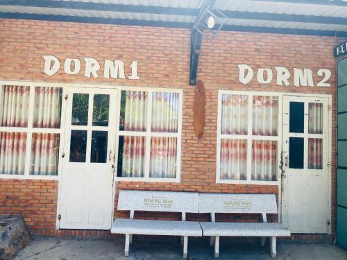 a brick building with two white doors and two benches at Hoang Nga Garden Guesthouse in Mui Ne