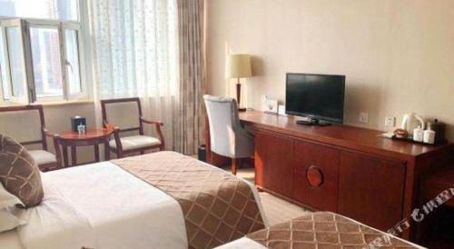 a hotel room with a bed and a flat screen tv at Shaanxi Business Hotel in Shanghai