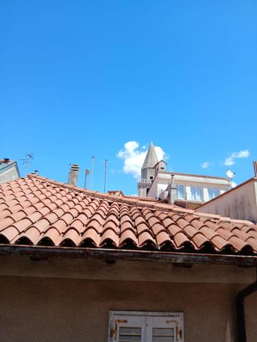 a red tile roof on a building with a tower at La Casa nel Borgo in Muggia
