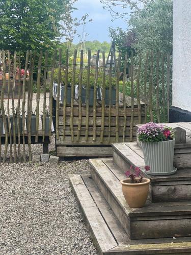 a wooden fence with stairs and flowers in a yard at Svabesholms Kungsgårds B&B och Pensionat Stenshuvud in Kivik