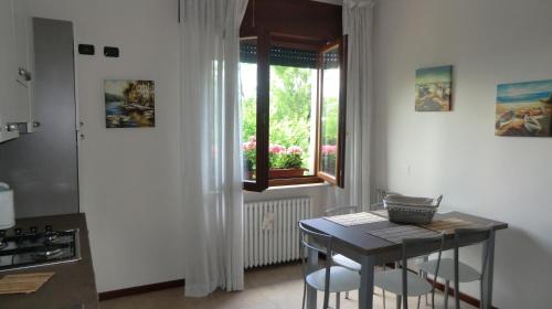 cocina con mesa, sillas y ventana en Appartamento Lago, en Peschiera del Garda