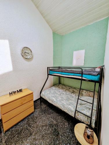 Cette chambre dispose de lits superposés et d'une horloge murale. dans l'établissement Logement privé dans Villa avec piscine, à Dalhunden