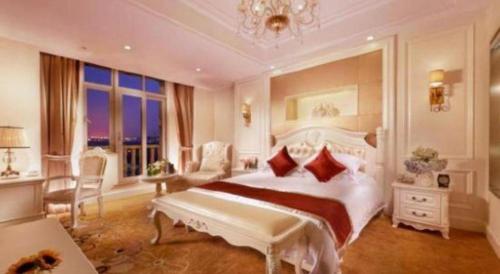 a large white bedroom with a large bed with red pillows at New century Manju Select Hotel Hongqiao Hub National Exhibition Center in Shanghai