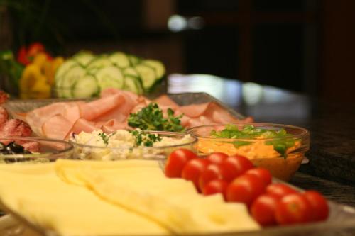 a buffet of food with tomatoes and vegetables on a table at Parkhotel in Bad Schallerbach