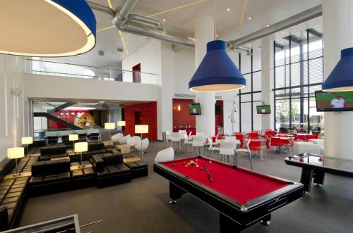 a billiard room with a pool table and chairs at Ramada Encore by Wyndham Guadalajara Sur in Guadalajara