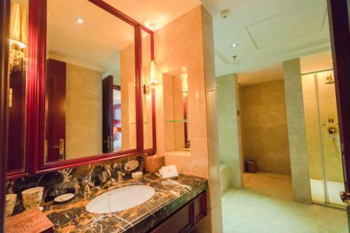 a bathroom with a sink and a large mirror at King Century Hotel in Zhongshan