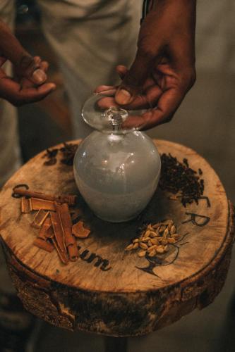 a person holding a vase on a wooden table at Mythic Suites & Villas by MJ Holidays in Grand Gaube