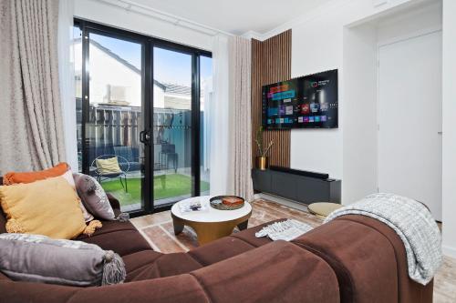 a living room with a couch and a tv at Quiet Suburban Escape Near Shops & Dining in Gepps Cross
