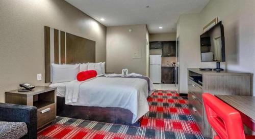a hotel room with a large bed and a television at Americas Best Value Inn and Suites IAH Airport North in Houston