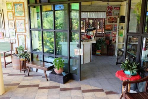 a store front with a table and a bench and windows at River Jam Amphawa in Amphawa