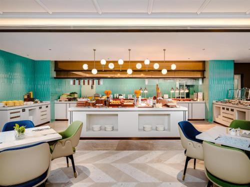a large kitchen with tables and chairs in a room at Hilton Garden Inn Taiyuan Jiefang Road in Taiyuan