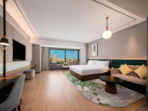 a hotel room with a bed and a couch at Hilton Garden Inn Taiyuan Jiefang Road in Taiyuan