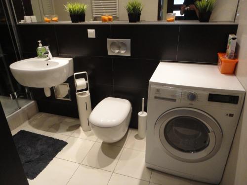 a bathroom with a washing machine and a sink at Angel Plaza Krakow in Krakow