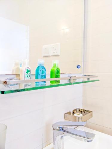 a bathroom with a glass shelf above a sink at Ivy Home in Nuwara Eliya