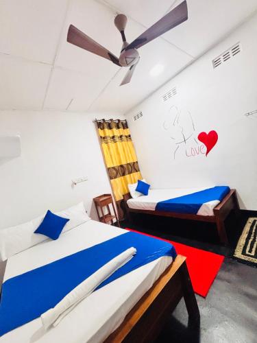 a bedroom with two beds and a ceiling fan at Spl inn in Trincomalee