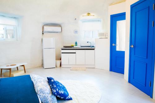 a room with a blue door and a kitchen at All That Water Pension in Gapyeong
