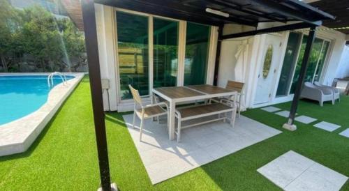 a patio with a table and chairs next to a pool at All That Water Pension in Gapyeong