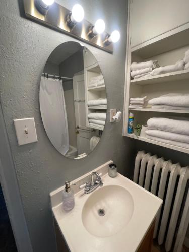 a bathroom with a sink and a mirror and towels at 19 century Victorian Home in Des Moines