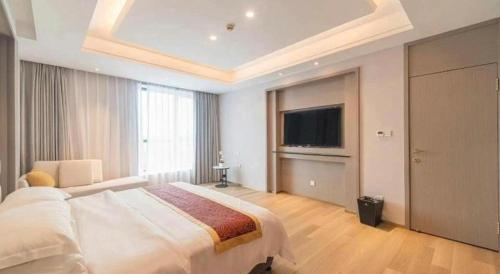 a bedroom with a large bed and a flat screen tv at Hefei Parkview Hotel in Hefei