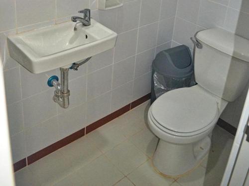a bathroom with a white toilet and a sink at Mayon Backpackers Hostel in Legazpi