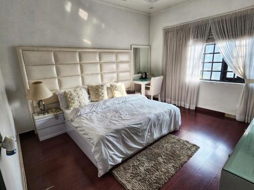 a bedroom with a large white bed and a window at The G8 in Noida