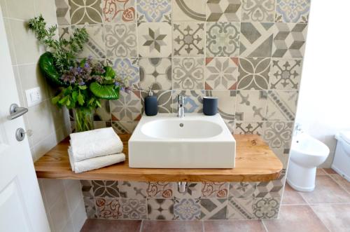 uma casa de banho com um lavatório branco num balcão de madeira em Casale Del Gelso em Genzano di Roma